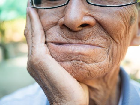 Close up of Elderly man biting on cotton gauze after tooth extraction, Tooth decay from not like brushing teeth. Oral care concepts.