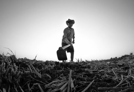 Elderly Asian farmers shoveling and prepare the soil with a spade for planting on sunset background.