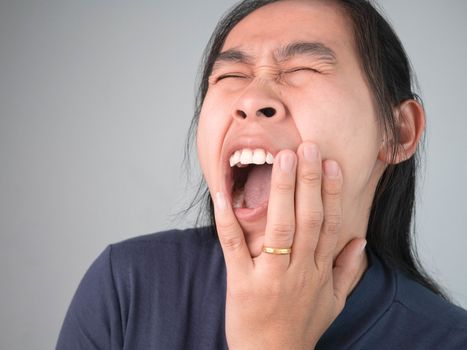 Woman catching on cheek because she have a toothache. Healthcare and medical concepts.