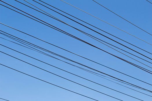 Electrical wires on blue sky background.
