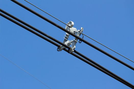 Electric cable wires with spacer damper on blue sky background.