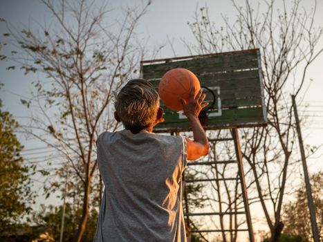 Asian elderly men playing basketball on playground on summer day. Healthy lifestyle and Healthcare concept.