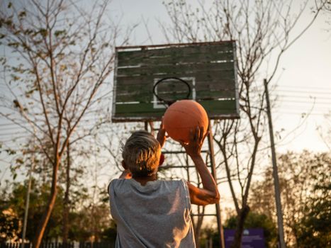 Asian elderly men playing basketball on playground on summer day. Healthy lifestyle and Healthcare concept.