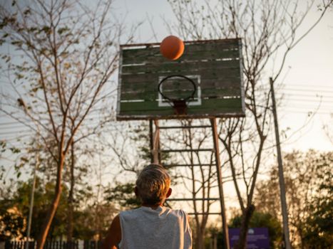 Asian elderly men playing basketball on playground on summer day. Healthy lifestyle and Healthcare concept.