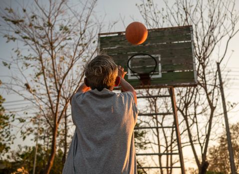 Asian elderly men playing basketball on playground on summer day. Healthy lifestyle and Healthcare concept.