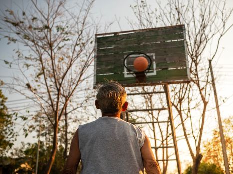 Asian elderly men playing basketball on playground on summer day. Healthy lifestyle and Healthcare concept.