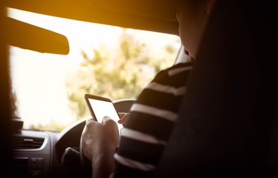 Business woman using a smart phone while driving. Dangerous activities on the road of driver.