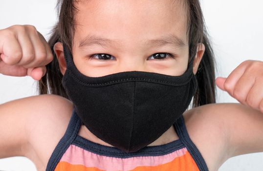 Portrait of Asian child girl wearing facial mask for protection from air pollution or virus epidemic on white background. Health care concept.