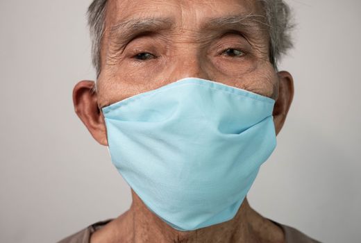 Portrait of Asian senior men wearing facial mask for protection from air pollution or virus epidemic on grey background. Health care concept.