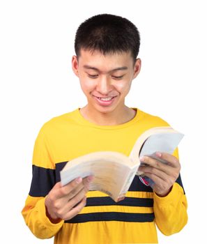 Close up portrait of a smiling handsome teenager boy in yellow long sleeve t-shirt and reading a book, stand over white background. lifestyle people concept.