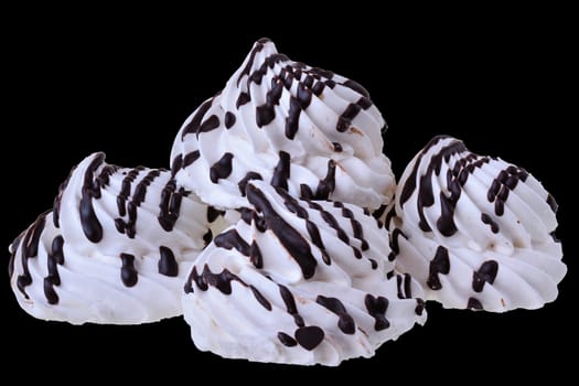 Meringue with chocolate closeup isolated on black background.