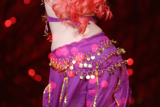 Belly Dancer Wearing Purple With Red Bokeh Background