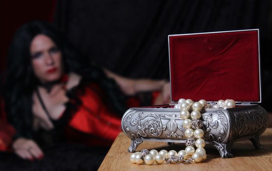 Vintage Jewelry Box with Pearls, Woman in red corset in background