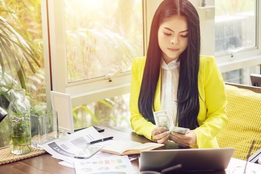 portrait of beautiful and confident Asian business woman in working with notebook laptop and book manage job work at workplace. happy businesswoman concept