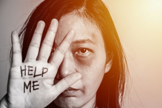 stop violence against women campaign. Asia woman with bruise on arms and face raised her hand for dissuade, hand write the word help me.