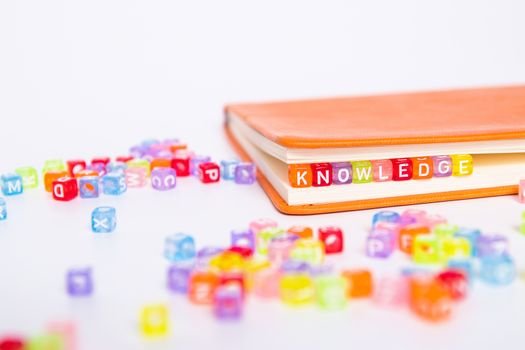 KNOWLEDGE word on colorful bead block as bookmark in book. education and knowledge concept