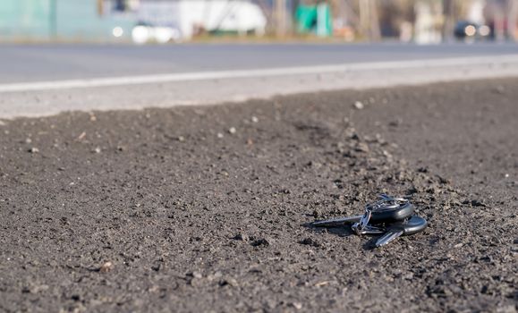 Lost bunch of keys lying on the side of the road near the asphalt pavement of the roadway