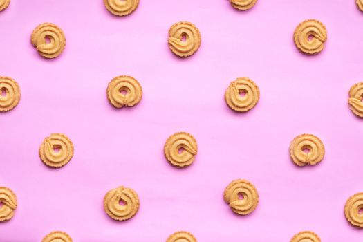 round Danish butter cookie isolated on pink background. cookies pattern for background. creative pastels and pastel minimalism concept.
