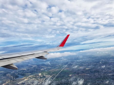 city view with clouds and sky as seen through window of an aircraft. travel and vacation concept