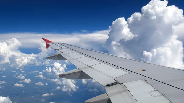 white clouds and blue sky as seen through window of an aircraft. travel and vacation concept