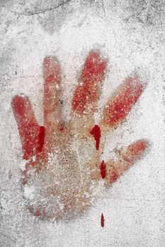An imprint of bloody hand on a white wall.