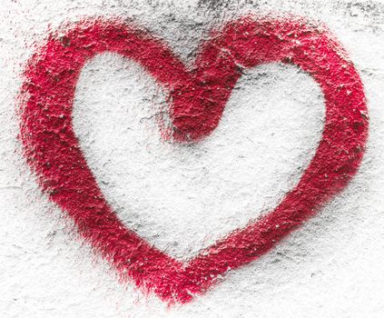 The profile of a red heart, drawn on a wall with spray.