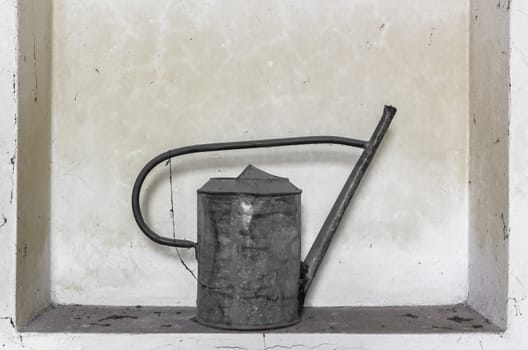 Old watering can abandoned and covered with cobwebs