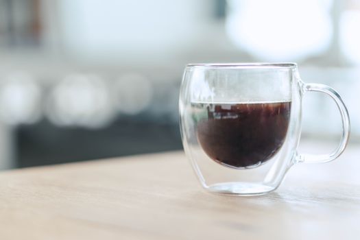 Closeup glass of hot americano coffee on wood table, selective focus, vintage tone