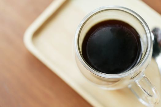 Closeup glass of hot americano coffee on wood table, selective focus, vintage tone