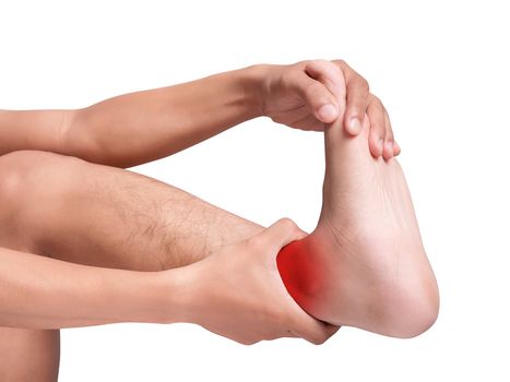 man suffering from cramp using hand massage painful foot and ankle. red color highlight at ankle , ankle muscles isolated on white background. health care ,medical concept. studio shot