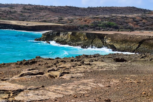 Arikok Natural Park on the island of Aruba in the Caribbean Sea with deserts and ocean waves on the rocky coast