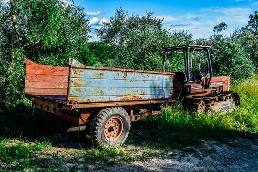 An old vehicle in the beautiful countryside of Peccioli in a sunny spring day near to olive trees, Valdera, Tuscany, Italy