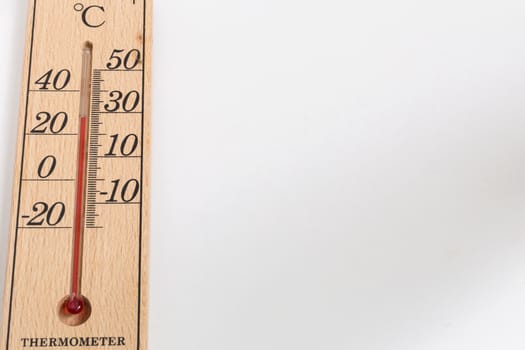 Thermometer made from wood on white background with 30 degree Celsius temperature.