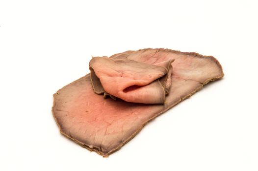 slices of roast beef neatly arranged on a white background