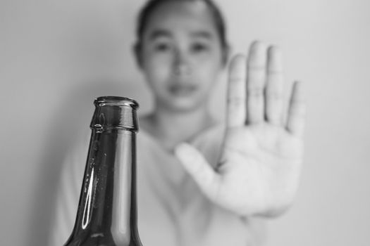Asian woman refuses alcohol; isolated on grey background. Stop alcoholism
