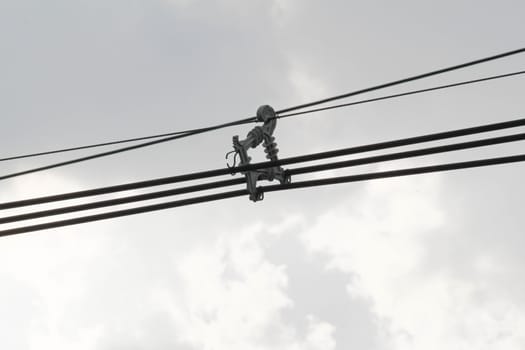 Cables of electric on dark gray dramatic sky with large clouds in rainy seasons.