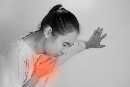 Asian young woman suffering from chest pain caused by heart disease.