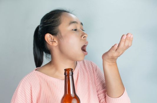 Depressed Asian young woman drink alcohol with take medicine. Dangerous lifestyle warning concept.