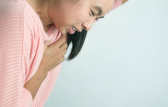 Asian young woman suffering from chest pain caused by heart disease.