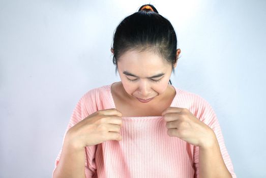 Portrait of Asian young woman looked at her breasts with unsatisfied and sad, wants to make plastic surgery on breast.