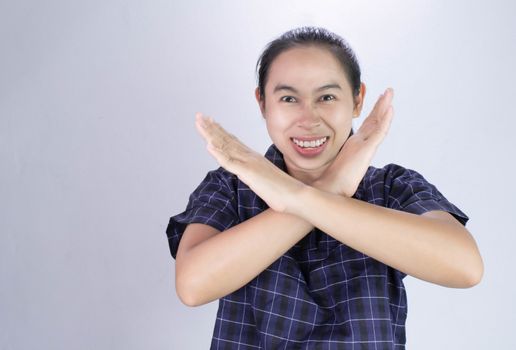 Portrait of Asian young woman in blue shirt, Show body language say no and Serious face isolated on grey background. Concept of rejection.