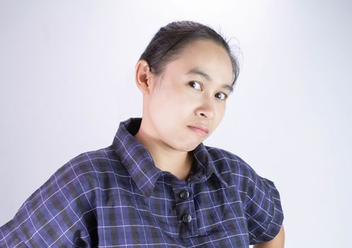 Close-up Angry face of Asian young woman in blue shirt with look to the camera.
