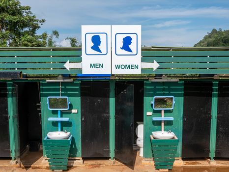 A sign outside public toilet in thailand with writing in English; Men and Women.