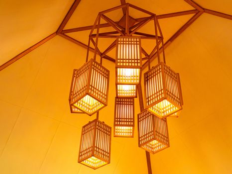 Lamps wooden wicker hanging on ceiling in the room. Decorating interior lantern concept.
