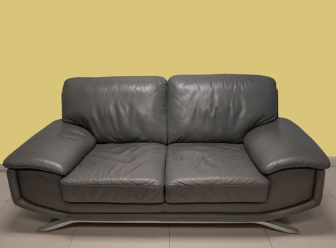 Front view of grey sofa on yellow background.