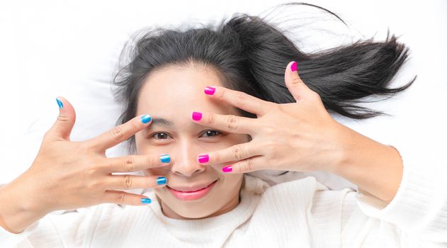 Close-up of female showing hands paint nail varnish with smiley face, self made manicure at home.