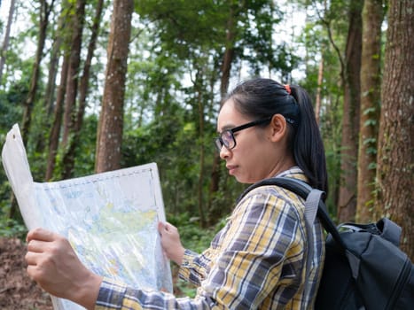 Young woman traveler with map and backpack relaxing outdoor at nature trail on summer vacations day. Lifestyle hiking concept.