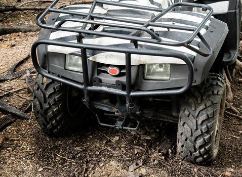 Front of ATV offroad parked alone at the forest.