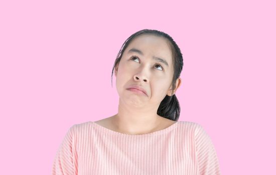 Asian woman bored and look empty space above, Isolated on pink background.