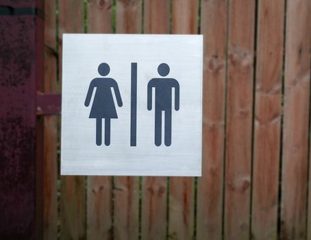 Restroom sign, a lady and a man on wood background at public toilet.